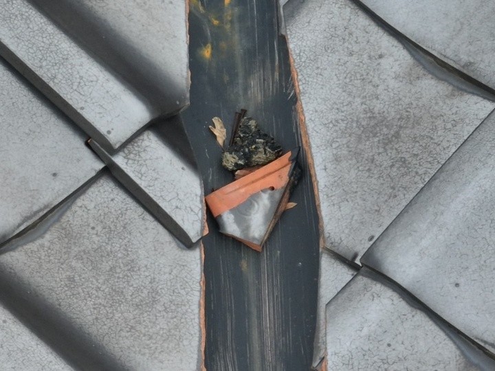 欠損した瓦が谷板金付近に落ちている状態