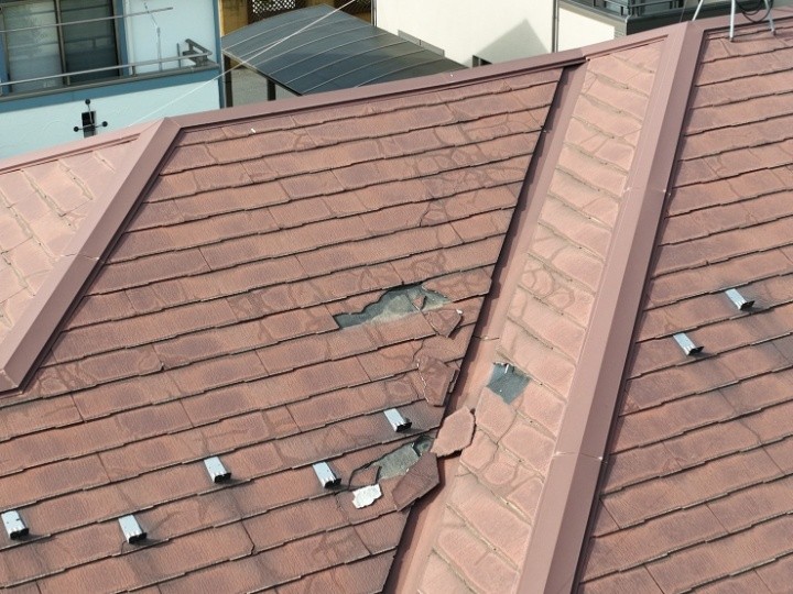 屋根材の欠けと浮きが重なり、防水性が落ちた状態