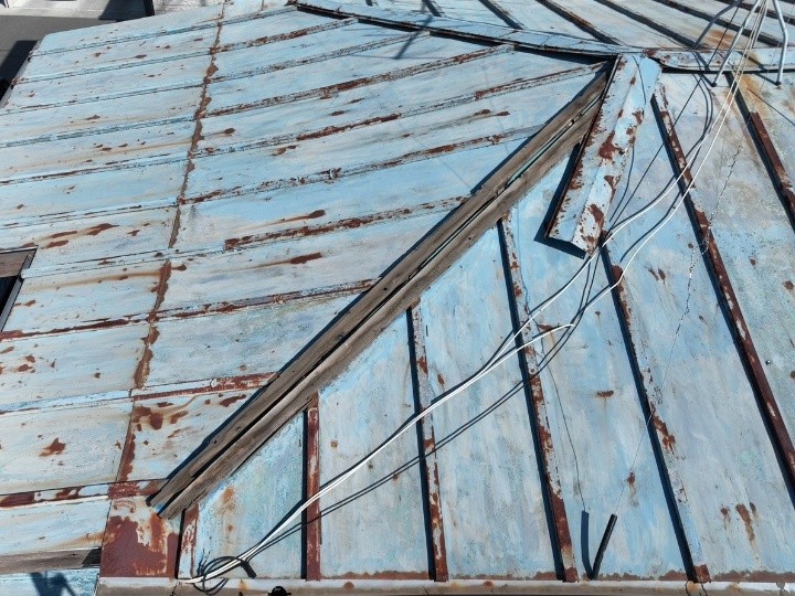 棟部の板金が外れ、下地が露出している状態